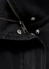 Anorak de estilo utilitario confeccionado en tejido de algodón tipo denim. Presenta cuello alto tipo embudo, cierre frontal con cremallera y botones a presión, y cuatro bolsillos de parche con solapa en la parte delantera. Diseño de corte oversize y manga larga.