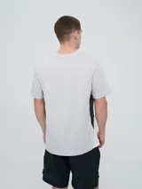 Remera deportiva Umbro modelo Vant, de color negro con paneles laterales grises y cuello redondo, diseñada para hombre.