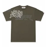 Remera de algodón color verde oliva con estampado gráfico en serigrafía plastisol. Presenta un diseño con caracteres orientales en blanco y tipografía cursiva en gris, con cuello reforzado y grifa de la marca en la manga.