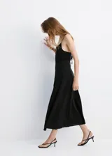 Vestido midi negro con tirantes finos, escote en pico y silueta evasé, confeccionado en mezcla de viscosa y poliamida.