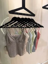Top corto de tirantes finos, con escote en V y diseño ajustado, con estampado a cuadros en tonos marrones y blancos.