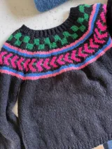 Sweater de punto tejido a mano en mohair, con diseño de canesú estampado en tonos azul, rojo, blanco y turquesa. Presenta cuello redondo y mangas largas.