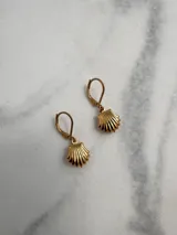 Aros colgantes de acero quirúrgico dorados con dije en forma de concha marina, con cierre tipo leverback.