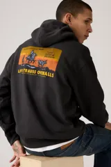 Hoodie negro de corte relajado con capucha y bolsillo canguro frontal. Presenta un parche o estampado circular en color naranja y amarillo en el pecho.