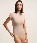 Body negro con cuello alto, mangas cortas y ajuste ceñido al cuerpo. Confeccionado en poliamida con elastano por la marca Cortelle.