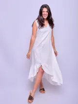 Vestido de lino sin mangas en color turquesa, con escote en V y detalle de volado en el ruedo con terminación asimétrica.