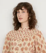 Camisa de gasa color beige con estampado de lunares marrones, cuello mao, mangas 3/4 abullonadas y cierre frontal con botones.