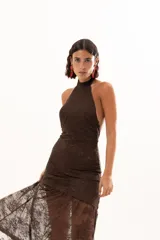 Vestido largo de encaje color chocolate, con escote halter y diseño ajustado en el torso que se abre en una falda con transparencia en el ruedo.
