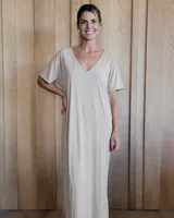 Vestido midi de rib elastizado, color beige, con cuello en V y mangas cortas. Presenta un corte holgado y fluido.