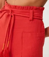 Short clochard de viscolino color beige, con cintura alta elastizada, bolsillos grandes aplicados en los laterales y detalle de cinturón de cuerda con borla.