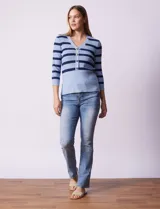 Buzo tejido de punto con diseño a rayas horizontales en tonos azul claro y azul marino. Presenta escote en V con una tapeta frontal decorada con botones metálicos y mangas tres cuartos.