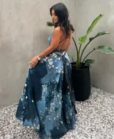 Vestido largo verde con diseño estampado tipo tie-dye y detalles dorados, de corte fluido, un solo hombro y diseño amplio.
