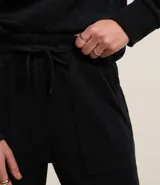 Pantalón jogger negro de algodón con cintura alta, elástico, lazo ajustable y tobillos ajustados.