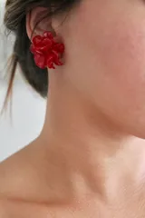 Aros tipo botón con forma de flor color rojo.