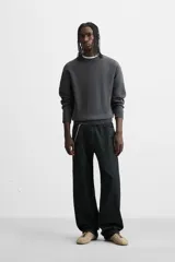 Jersey de punto de tacto suave con diseño de rayas horizontales anchas en color rosa claro y marrón oscuro. Presenta cuello redondo, manga larga y terminaciones en rib.