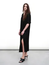 Vestido midi negro con cuello en V, mangas cortas y aberturas laterales. Confeccionado en tejido fluido con un toque de lurex.