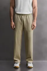 Pantalón jogger de corte relajado confeccionado en tejido compacto de algodón. Presenta cintura elástica con cordón interior, bolsillos frontales en la cadera y un bolsillo trasero de plastrón.