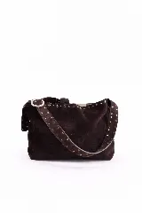 Cartera tipo hobo de cuero gamuzado color marrón oscuro, con correa ancha ajustable decorada con tachas metálicas y hebilla plateada. Presenta detalles de tachas en el borde superior y cierre principal.