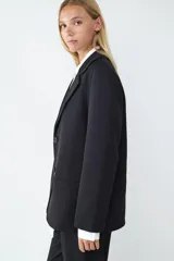 Blazer de corte oversize con cuello de solapa, manga larga y cierre frontal con botón. Cuenta con bolsillos delanteros con solapa.