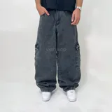 Pantalón jean negro de corte ultra baggy, con bolsillos cargo laterales y textura rústica.