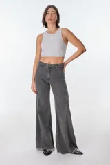 Pantalón de pierna ancha con acabado brillante, confeccionado en lino. Presenta un diseño de tiro medio con cierre de botón y cremallera, bolsillos traseros y etiqueta de marca en la cintura.