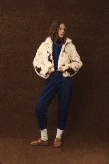 Zapato tipo zueco de cuero color beige, con diseño tejido artesanal en todo el contorno y ajuste mediante correa con hebilla metálica en el empeine.