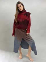 Buzo de lana merino afieltrada con diseño artesanal de efecto degradado en tonos violeta y fucsia. Presenta cuello alto, hombreras marcadas y corte holgado.