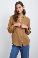 Camisa blanca de algodón con textura arrugada, corte clásico, cuello camisero, manga larga con puños abotonados y bolsillo de parche en el pecho.