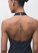 Mono largo de denim oscuro con cuello halter y espalda descubierta. Presenta un diseño de corte recto y holgado con bolsillos laterales y cierre de cremallera en la parte posterior.