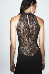 Vestido largo negro de cuello halter con detalles de encaje en la parte superior y espalda. Cuenta con corte en línea evasé y cierre posterior con abertura y botón.