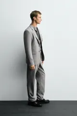 Blazer slim fit de color gris, confeccionada en tejido con lana. Presenta cuello con solapas de muesca, cierre frontal con un botón, bolsillos de solapa en la cadera y bolsillo de vivo en el pecho.