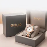 Reloj analógico Mini Focus con movimiento de cuarzo japonés, caja de aleación metálica y malla de acero inoxidable bicolor en tonos plata y oro rosa. Presenta una esfera blanca minimalista con indicadores de hora lineales y ventana de fecha.