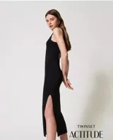 Vestido largo negro de tejido de punto con cuello redondo y espalda descubierta con borde de lentejuelas. Tiene tirantes anchos, abertura lateral y corte ajustado.