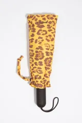 Paraguas plegable Bimba y Lola con funda a juego con estampado animal print tipo leopardo en tonos amarillo y marrón. Cuenta con mango negro texturizado y tira para colgar.
