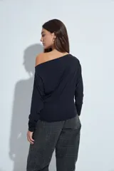 Top de manga larga con escote bote amplio, diseñado para usar ligeramente caído sobre los hombros. Presenta una silueta entallada y tejido liso, liviano y adaptable al cuerpo.