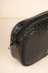 Cartera tipo bandolera de cuero sintético con diseño trenzado, cierre superior y detalle de borla lateral. Incluye correa ajustable y desmontable.