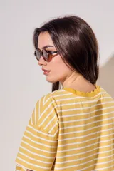 Lentes de sol polarizados de diseño ovalado con armazón carey en tonos marrones y cristales oscuros.