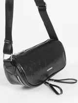 Riñonera de cuero vegano en color bordó con acabado brillante y efecto arrugado. Cuenta con dos compartimentos con cierre y correa ajustable de cinta negra.