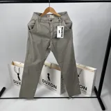Pantalón de vestir color gris claro, confeccionado en tela gabardina.