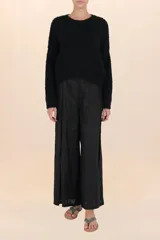 Suéter negro de tejido suave y esponjoso, con cuello redondo y mangas amplias de volumen.