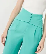 Pantalón capri color verde agua, de tiro alto, con cintura ancha, pala sobrepuesta con pespuntes y botones forrados.