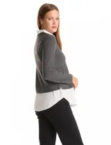 Buzo combinado marca Rio & Rian, con diseño de efecto capas que simula una camisa blanca debajo. Presenta un cuerpo de tejido de hilado fino en color beige con escote en V, y cuello y ruedo de gasa blanca.