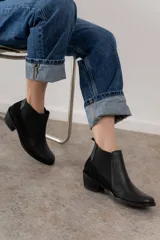 Bota corta de cuero color marrón con elásticos laterales, taco bajo y punta redondeada.