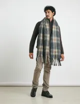 Pantalón de vestir verde oliva, de corte slim fit, sin pinzas, con bolsillos laterales y traseros. Se ajusta a la cintura con cinturón de cuero marrón.