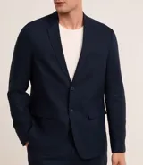 Saco de traje masculino confeccionado en mezcla de lino y viscosa, con cierre frontal de dos botones, bolsillos laterales con solapa y medio forro interior.