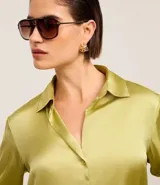 Camisa de satén color verde oliva, de manga larga con puños abotonados y cuello inglés.