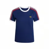 Remera de manga corta azul marino con cuello redondo blanco. Presenta el logo del trébol de Adidas en dorado en el pecho y tres franjas decorativas en los hombros en rojo, blanco y azul.