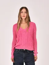 Buzo de tejido de punto color verde menta, con cuello en V y diseño de trenzas en el frente y mangas. Presenta un efecto desgastado o lavado.