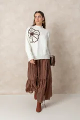 Pollera larga de estilo bohemio en color chocolate, confeccionada en tela satinada con caída fluida. Presenta un diseño de corte amplio con un volado en el ruedo y cintura elastizada para mayor comodidad.
