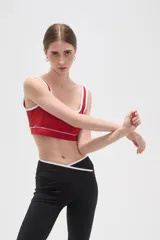 Top deportivo de poliamida color rojo, con escote cuadrado, breteles finos y detalles de ribete blanco en el cuello y bajo el busto.